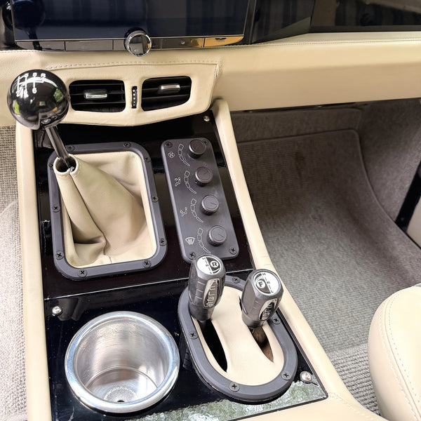Center console from above: shifter, climate control knobs, transfer case lever and aluminum cup holder