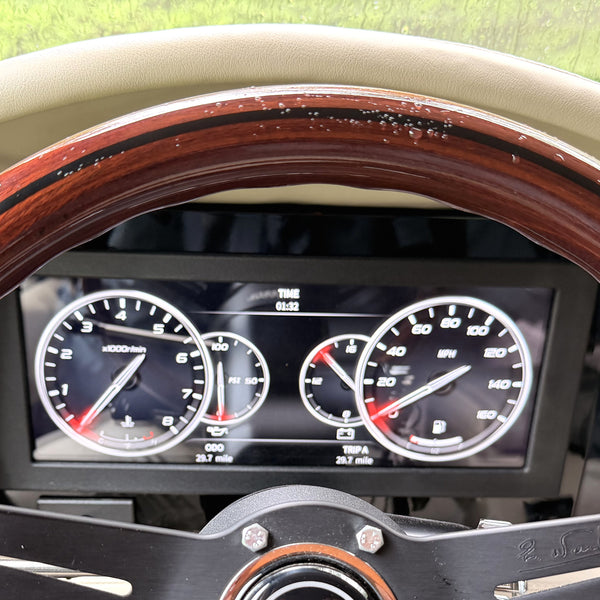 Wood-rim steering wheel in front of the AutoMeter InVision LCD gauge cluster